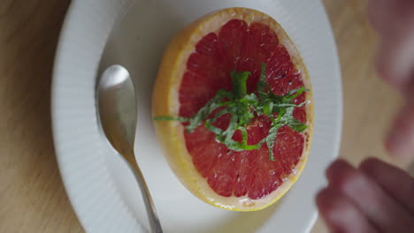 Sprinkle-fineley-chopped-pepper-mint-over-a-grapefruit