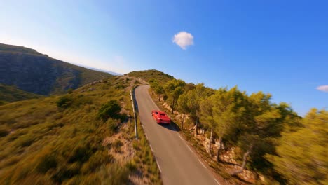 FPV-aerial-following-a-red-Ferrari-along-a-scenic-country-highway-in-Spain