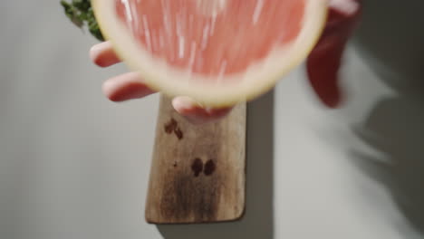 Hand-holding-a-grapefruit-in-the-kitchen