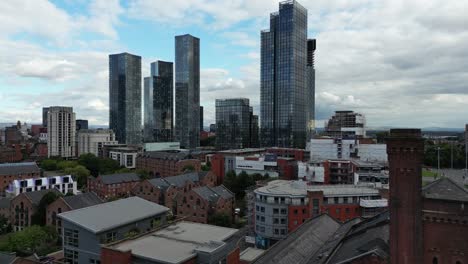 Aerial-drone-flight-over-the-rooftops-of-Castlefield-Quays-showing-a-view-of-the-skyscrapers-in-Manchester-City-Centre