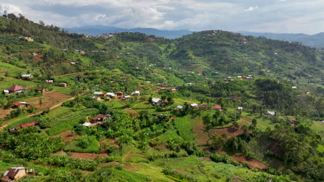 Hohe-Drohnenaufnahme-Von-Landhäusern,-Die-Die-Berglandschaft-In-Ruanda-Prägen