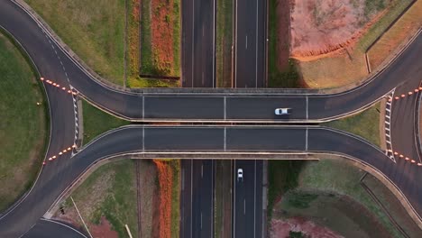 Aerial-birdseye-rising-over-ring-road-on-road-at-sunset