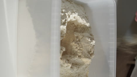 Gießen-Sie-Trockenhefe-In-Einen-Plastikbehälter-Mit-Mehl-Und-Machen-Sie-Zu-Hause-Brotteig