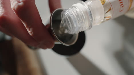 Pouring-simple-syrup-into-jigger-and-into-cocktail-shaker-Close-Up-Top-Shot
