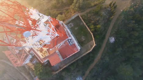 FPV-aerial-flying-up-and-over-the-top-of-a-communications-tower