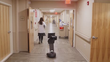 Robot-De-Telemedicina-Navegando-Por-El-Pasillo-Del-Hospital-Junto-A-Una-Enfermera
