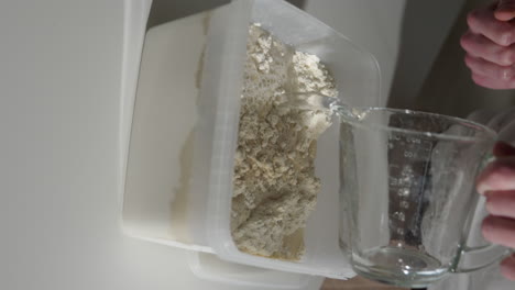 Gießen-Sie-Wasser-In-Einen-Plastikbehälter-Mit-Mehl-Und-Hefe-Und-Bereiten-Sie-Den-Teig-Für-Selbstgebackenes-Brot-Vor