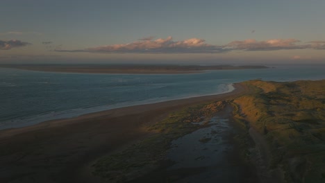 Last-sunlight-shines-on-Omaui-beach-in-New-Zealand-at-New-River-estuary,-aerial