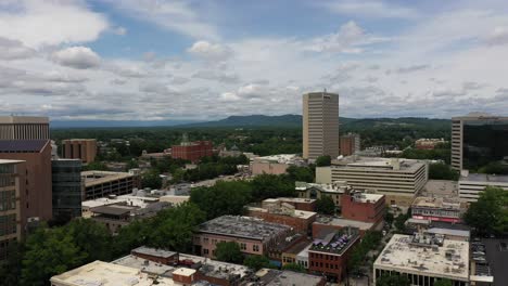 Aerial-shot-over-the-city-of-Greenville-in-South-Carolina,-buildings-under-a-blue-sky-with-clouds