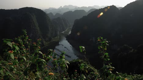 Vista-Panorámica-Del-Río-Desde-El-Mirador-Hang-Mua-Con-Flores-En-Primer-Plano-En-4k,-Ninh-Binh,-Vietnam