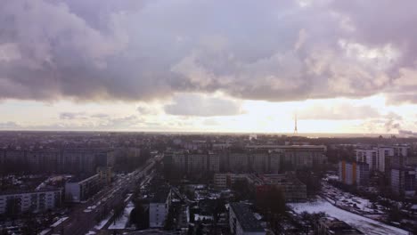 Aerial-drone-ascent-revealing-Riga-city-while-it-snows-simulating-the-Soviet-times