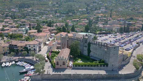 Circular-aerial-shot-to-castle,-closer,-long-shot-over-Castello-Scaligero-Castle-on-Lake-Garda-in-Italy