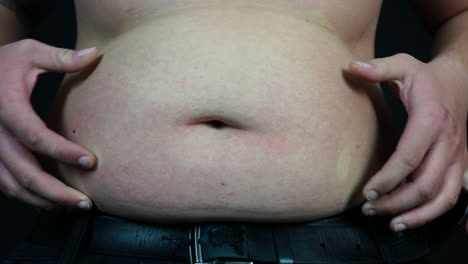 Young-Fat-Man-Squeezing-His-Belly,-Overweight,-Bad-Diet-and-Junk-Food-Concept,-Slow-Motion
