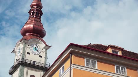 Close-up-of-part-of-the-old-town-hall,-today-called-Palais-Rosenberg-and-tower-of-the-parish-church-in-Klagenfurt