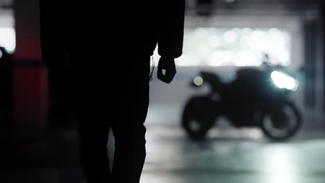 Silhouette-Young-Man-Walks-up-to-His-Black-Motorbike-and-Climbs-onto-it-and-Revs-Throttle,-Cinematic-Slow-Motion-Wide-Shot