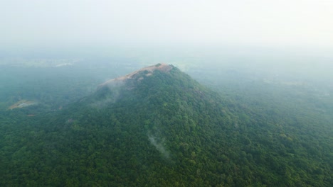 Luftaufnahme-Nach-Vorne-über-Den-Sigiriya-Pidurangala-Felsen-Bei-Einem-Nebligen-Sonnenaufgang