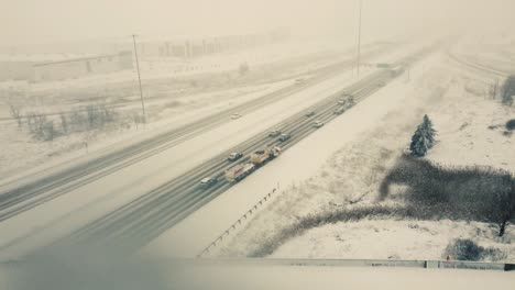 Aerial-forward-view-over-vehicles-running-on-a-highway-in-a-snow