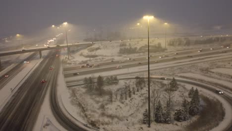 Aerial-forward-view-of-junction-of-roads-full-of-cars-under-snow