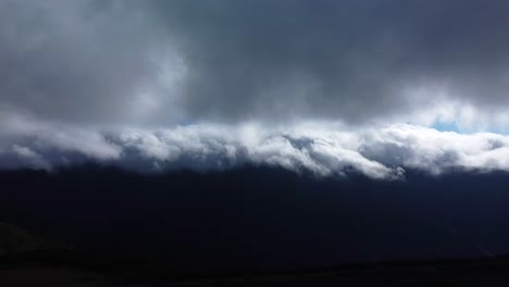 Vista-De-Drones-De-Nubes-Bajas-Y-Oscuras-En-Las-Montañas-De-La-Isla-De-Madeira,-Toma-Panorámica-Del-Cielo-Místico