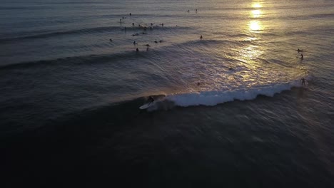 Surfer-Fängt-Eine-Welle-Im-Reflektierenden-Goldenen-Schein-Des-Sonnenuntergangs,-Hawaii
