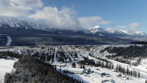 Snowy-valley-on-sunny-winter-day-with-mountain-range-in-background,-Golden-town,-British-Columbia-in-Canada