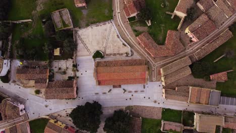 Top-down-establisher-aerial-of-Tratalias-square-and-church,-dolly-out,-day