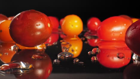 Push-in-macro-video-of-wet-cherry-tomatoes-on-a-wet-reflective-surface