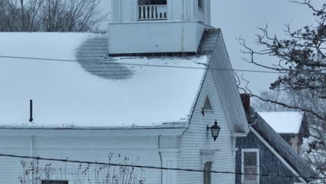 Monson-communal-church-tower-ascending-aerial-winter-snowstorm