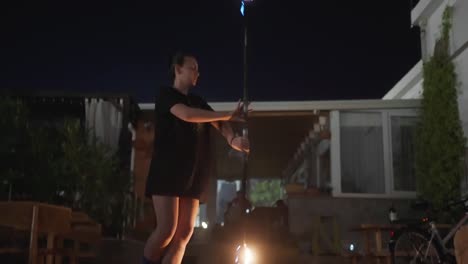 Female-Fire-Dancer-and-Performer-Spinning-Burning-Torch-at-Night,-Slow-Motion