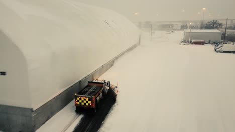 Ein-Schneepflug-Bei-Der-Arbeit,-Um-Die-Riesigen-Schneemengen-Rund-Um-Einen-Hangar-In-Toronto,-Ontario,-Kanada,-Zu-Bewältigen