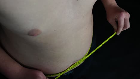Young-Man-Measuring-His-Belly-With-Meter-Close-Up
