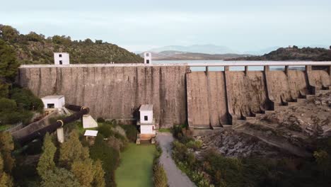 Establisher-aerial-view-of-large-Dam-in-Tratalias,-Sardinia,-lowering,-day