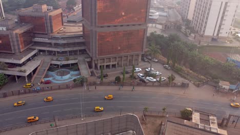 Post-Centrale-roundabout-by-immeuble-de-la-mort-downtown-Yaoundé,-revealing-aerial-shot