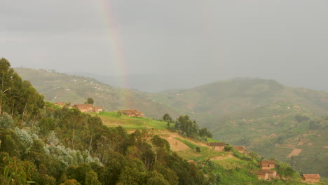 Mittlere-Aufnahme-Eines-Hauses-Am-Hang-Eines-Hügels-In-Ruanda-Mit-Einem-Regenbogen-Auf-Dem-Dach-Des-Hauses
