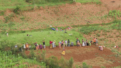 Weitwinkelaufnahme-Einer-Gruppe-Von-Menschen,-Die-Einen-Hügel-Im-Ländlichen-Ruanda-Pflügt