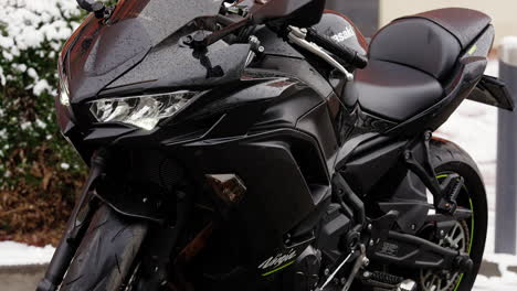 Black-and-beautiful,-Kawasaki-Ninja-motorcycle-parked-in-the-snow