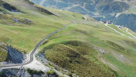 Isolated-cyclist-pedaling-along-road-of-Col-de-la-Loze-mountain-pass,-savoy-in-French-Alps