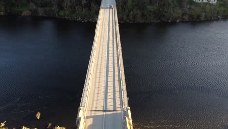 Car-crossing-the-Vila-Velha-de-Ródão-bridge-over-the-Tagus-river,-Aerial-Tilt-down-vhiew