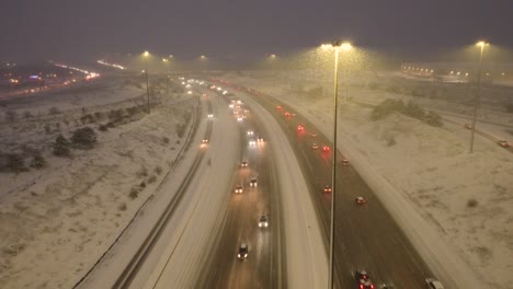 Aerial-view-of-a-winter-highway-covered-with-snow-during-nighttime