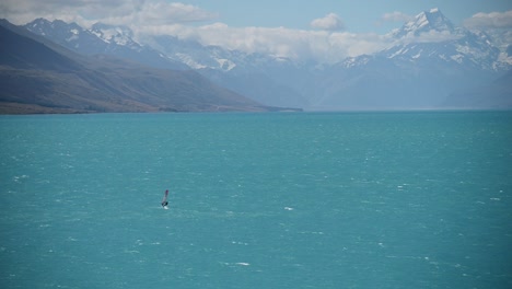 Fast-wind-surfer-on-blue-glacial-lake-with-New-Zealand's-highest-mountain-in-background