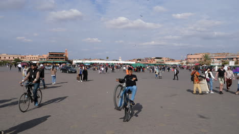 People-walking-around-Jemaa-El-Fna-busy-market-square-downtown-district,-Marrakesh,-Morocco