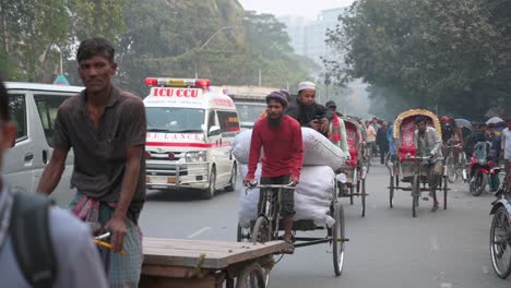 Slow-motion-footage-of-vehicles,-an-ambulance,-and-Bangladeshi-commuters-driving-on-a-road-in-Dhaka