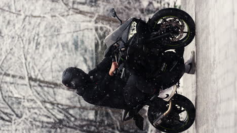 Vertikale-Aufnahme-Eines-Fahrers,-Der-Im-Schneefall-Auf-Einem-Motorrad-Sitzt