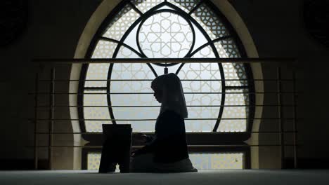 Junge-Hijabi-Muslimin-Liest-Den-Koran-Am-Fenster-Im-Islamischen-Stil