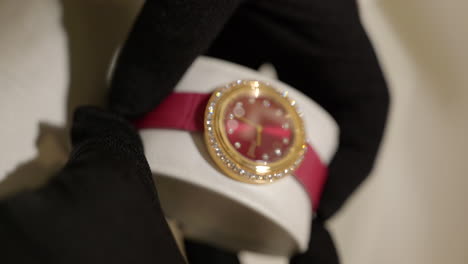 VERTICAL-Shallow-focus-on-luxurious-gold-and-red-Piaget-wristwatch-details,-shimmering-front-view-on-dial