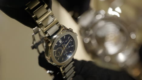 VERTICAL-Gloved-hands-presentation-of-Piaget-mechanical-wristwatch-with-bokeh-blurred-reflection-in-glass