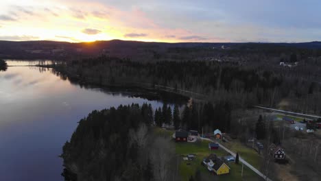 Drone-Subiendo-Y-Filmando-La-Puesta-De-Sol-Junto-A-Un-Lago-En-Suecia