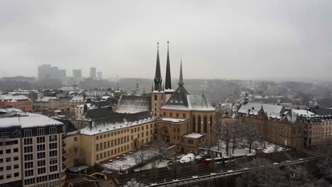 Tiro-De-Drone-De-La-Catedral-De-Notre-Dame-En-La-Ciudad-De-Luxemburgo-Un-Día-De-Nieve