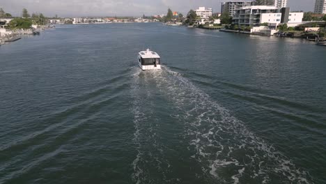 5-February-2023---Aerial-views-over-boat-on-canal-in-Surfers-Paradise,-Gold-Coast,-Queensland,-Australia