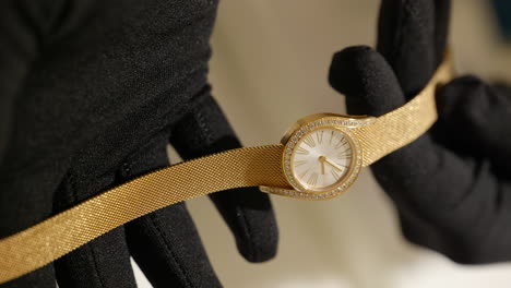 VERTICAL-Salesperson-hands-showing-elegant-gold-sparkling-Piaget-wristwatch-dial-details-and-craftsmanship